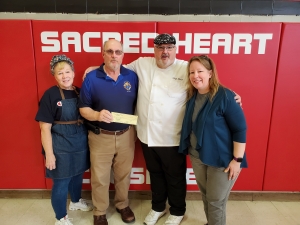 Dennis Rose represents the Knights of Columbus Council #3805 from Reedsburg with a donation of $500 to Sacred Heart Catholic School in Reedsburg. This donation was given to the school lunch program. Pictured from left are Cynthia Tourdot, cook's assistant; Dennis Rose, Knights of Columbus; Chef Mark Lancaster and April Duvalle, administrative assistant. (Submitted photo)